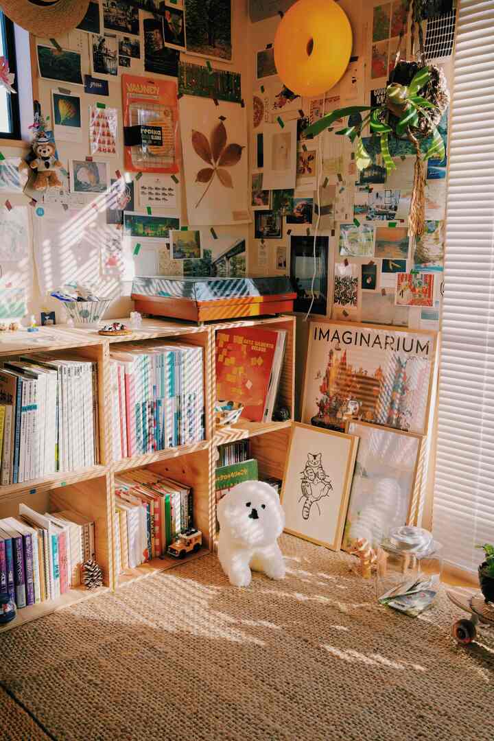 ナチュラルな色調の居心地の良い小さな部屋、本棚と壁飾りが配置された雰囲気のあるインテリア