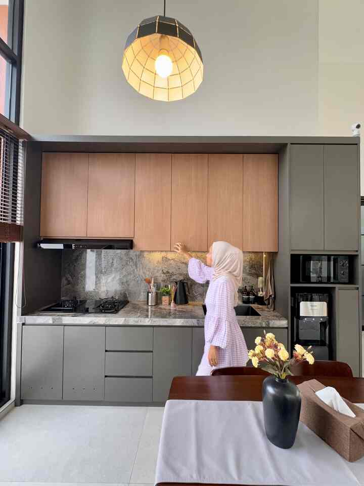 Modern kitchen with natural and wood tones, featuring central pendant light and dining table creating a neat space