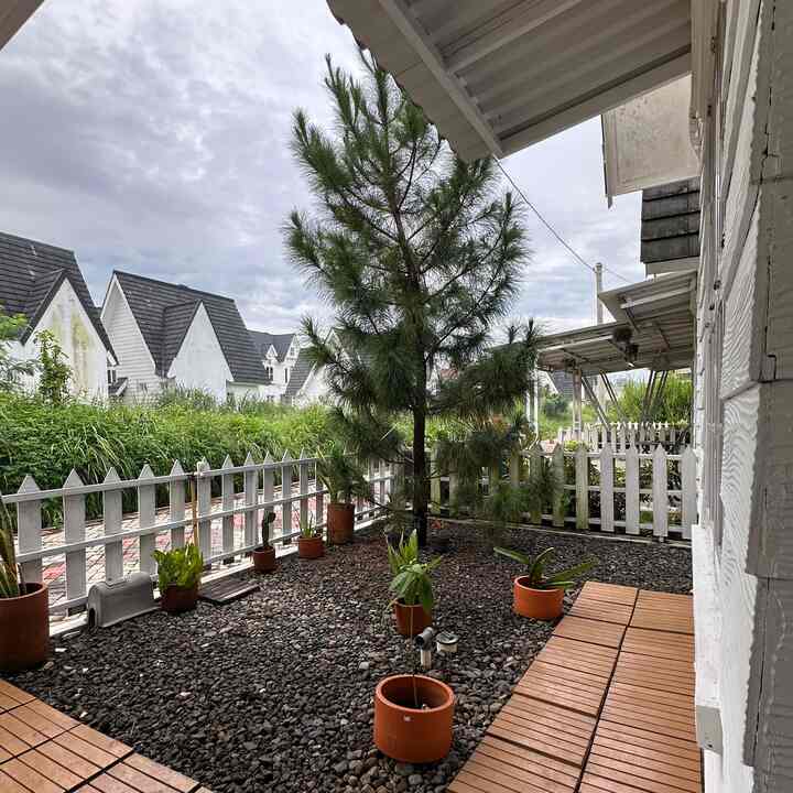 Taman ini awalnya full rumput tapi karena banyak tumbuh rumput liar jadi kami putuskan untuk buat taman kering seperti ini.  Tanah ditutup dengan paranet, pasir dan batu split.  Hanya pohon cemara bawaan developer yang kami pertahankan.  
Untuk mempercantik kami tambahkan wood deck dan pot tanah liat.  Untuk wood deck kami repaint dengan cat khusus eksterior, selain lebih cantik juga lebih tahan lama ketika diletakkan di luar ruangan.  Pagar kayu bawaan developer juga kami repaint sendiri.
Semua bahannya sangat affordable dan mudah didapatkan di toko bangunan mana pun.  Dengan begini taman ini jadi lebih praktis dan minim perawatan 🫶

#wooddeck #pottanahliat #lamputamansolar #batusplit #catwoodstain #materialrenovasi #materialmurah #tamandepan #halamandepan #frontyard