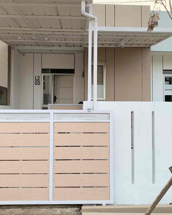 An exterior space showing a beige and white toned house entrance with a fence