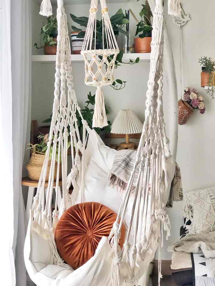 Natural color tone living room featuring macrame decor and plants creating a cozy relaxation space