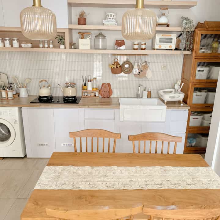 Natural wood tones and white kitchen with dining table, creating a clean and simple atmosphere