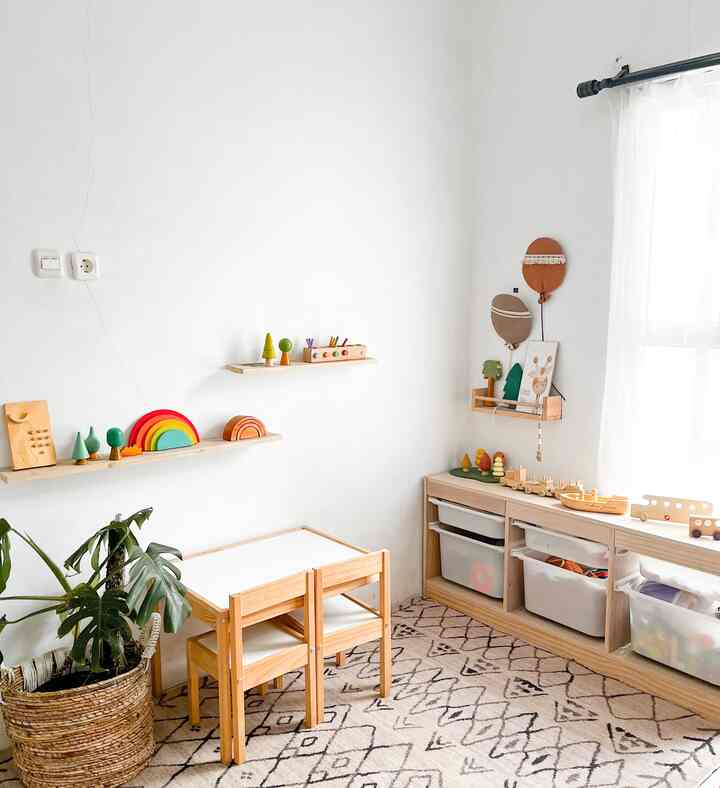 Natural modern kids' room with white walls and wood tone furniture, featuring a kids' desk and organized toy storage