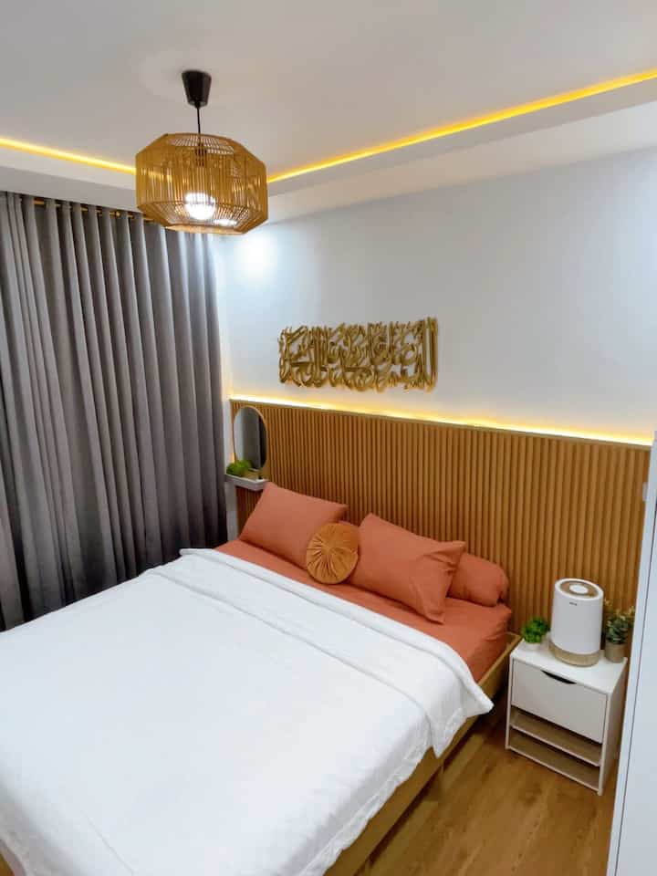 White and brown toned bedroom featuring wood headboard and rattan pendant light with cozy atmosphere