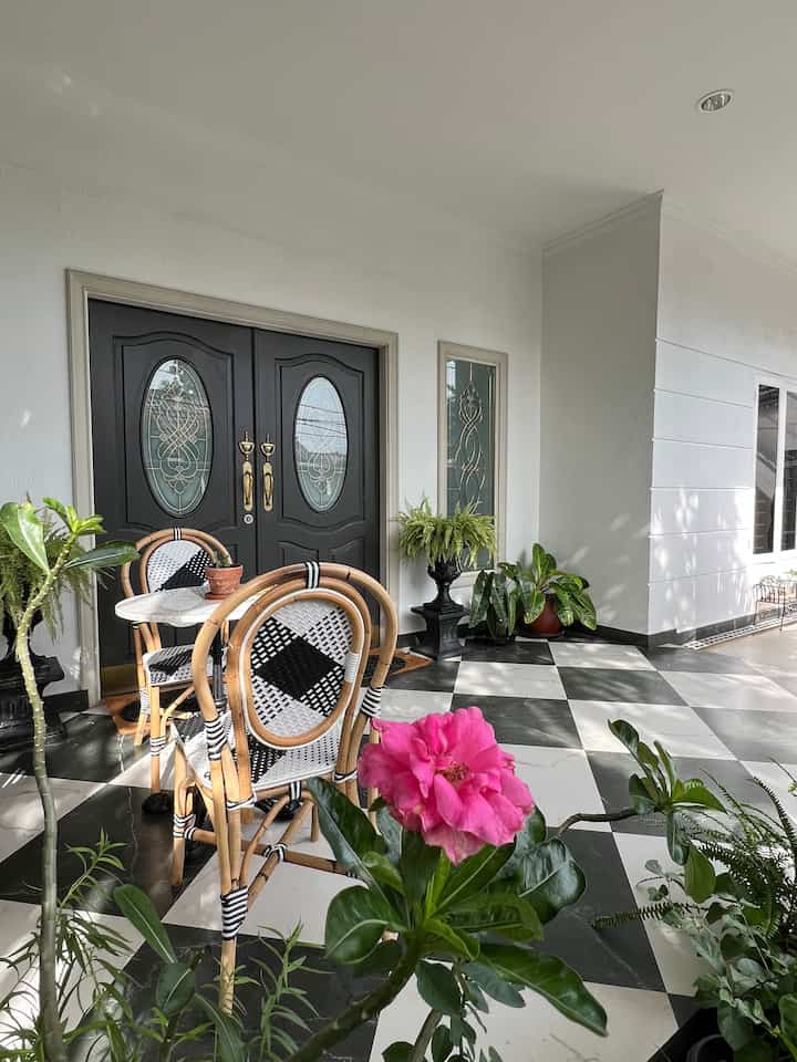 The characteristic of a bistro-style terrace in Paris is the use of a small round marble table paired with beautifully designed rattan chairs, usually placed facing the street to attract the attention of passing Parisians. 

This time #rumahlimut will try to share the exterior of our house, namely the terrace. 

The size of our terrace is 3x7 m with a 60x60 granite floor installed directly on ceramic tiles without dismantling the old floor to save money and time. 

Still in the same area is the garden area which extends to the carport area. 

Previously, this area was land where we planted grass and various trees, but because it did not grow well, the soil made the terrace area dirty if it was exposed to heavy rainwater. 

Therefore, during the renovation, we decided to cover all areas of this land with natural stone templek with white grout accents. 
We moved the plants to various pots arranged around the terrace. 

This outdoor area is inspired by various 𝒑𝙖𝒕𝙞𝒐 in Europe, because we love their 𝙩𝒊𝙢𝒆𝙡𝒆𝙨𝒔, 𝒆𝙡𝒆𝙜𝒂𝙣𝒕 style, looks 𝒔𝙩𝒚𝙡𝒊𝙨𝒕 but still 𝒉𝙤𝒎𝙚𝒚.

Hopefully it inspires friends.

#inspirasiteras
#terrace
#garden
#porch
#seating area
#exterior
#catkamprot
#granitefloor
#batualam
#handel pintu
#doorbrasshandle
#doorknocker
#maximalist