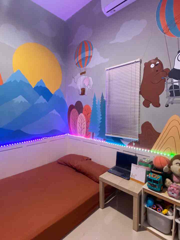 Bright and cozy kids' room with animal murals and yellow sun, featuring a brown mattress and desk in a narrow compact space