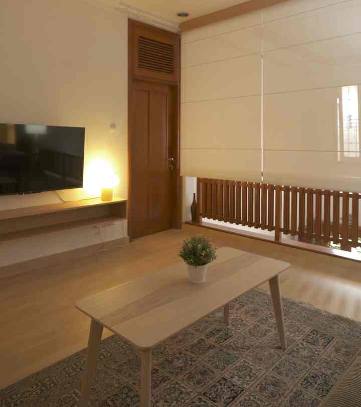 Beige-toned living room featuring wood-tone coffee table and TV stand with cozy lighting and clean interior design