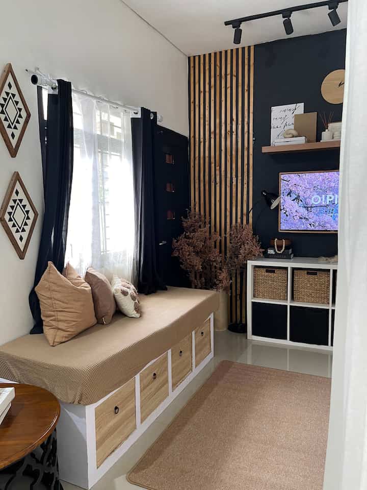 Style rumah kami yang sekarang itu Warm and Bold, karena di dominasi dengan warna hitam dan ada kesan warm dari perintilan kekayuan dan warna earth tone agar lebih cozy dan tidak monotone.

Hampir semua ruangan sudah kami dekorasi dengan tema ini, kecuali di kamar anak.

Elemen di rumah ini banyak dibuat #makeoverlowbudget dengan #DIYlowbudget seperti wooden slat wall, ambalan, dan window seater sekaligus storage kami buat dari kayu jati belanda. 
 
#warmandbold #moderndarkinterior #blackandwood #roomdecorinspo #aesthetichomedecor #livingroom #ruangtv #inspirasiruangtv #ruangkeluarga #dekorasiruangtv #dekorasiruangkeluarga #rumahmungil
