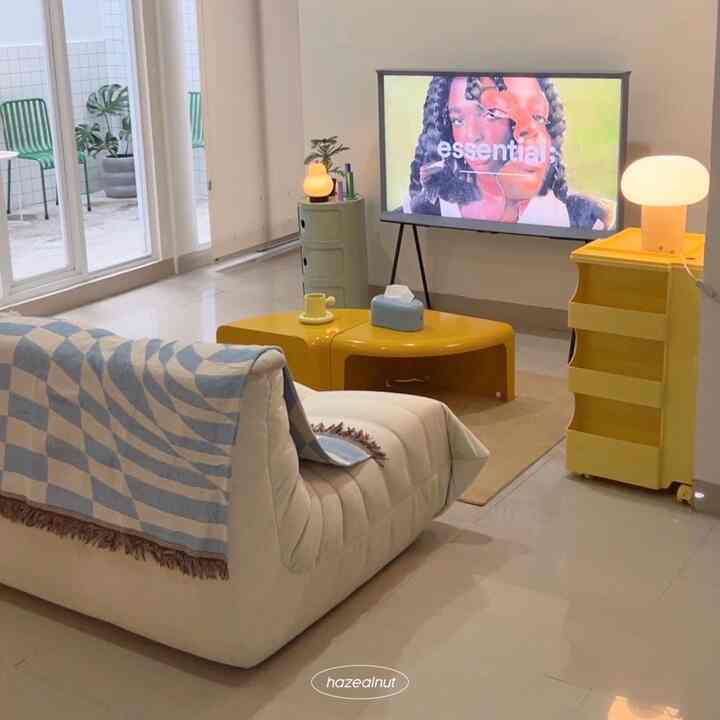 White-based modern living room featuring yellow furniture, sofa, TV stand, and table lamps creating a cozy atmosphere