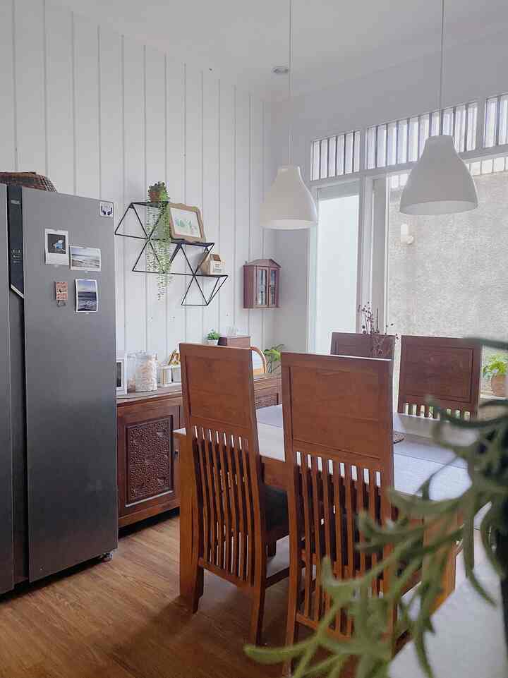 White walls and brown wooden furniture in a kitchen with natural lighting and plants creating a natural atmosphere