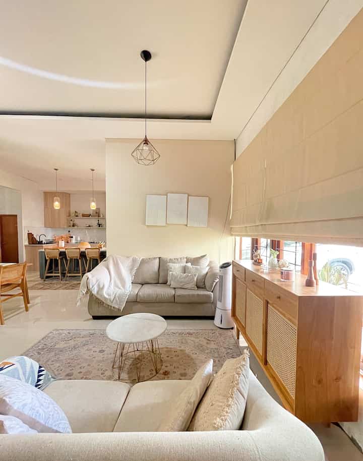Natural beige-toned living room featuring sofas and wooden furniture, creating a simple and warm atmosphere