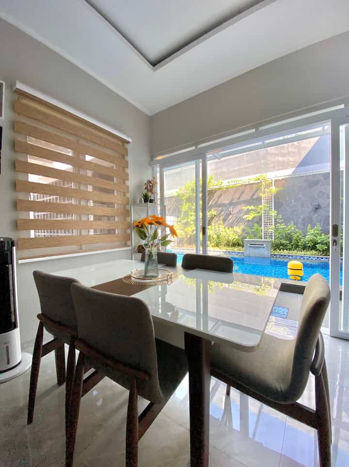 Ruangan ini menurut kami paling estetik, karena view nya langsung menghadap ke pool, sehingga ada sensasi berbeda saat kami berada di ruangan ini, meskipun hanya ngobrol ataupun sambil makan.

Yang membuat ruangan ini tampak lebih eye catching adalah penempatan roller blind zebra pada jendela sehingga membuat privasi tetap terjaga tapi juga tetap cantik.

Ada nya pintu kaca besar yang langsung mengarah ke pool juga menjadi point penting yang membuat seolah ruangan ini menyatu dengan area pool

#aestheticroom 
#aesthetichomedecor
#homestyling
#minimalist
#rumahcluster
#rumahdeveloper
#bandung
#livewithkids
#petparent