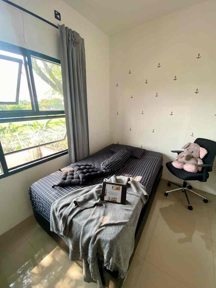 Gray and white toned kids' room featuring a bed, armchair, and anchor-patterned wall decor with a simple and calm atmosphere
