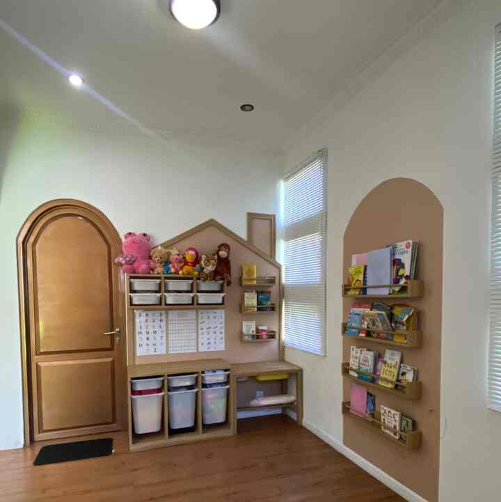 Beige-tone walls and wood-tone furniture in a kids' room featuring toys and bookshelves, creating a bright and cozy study area
