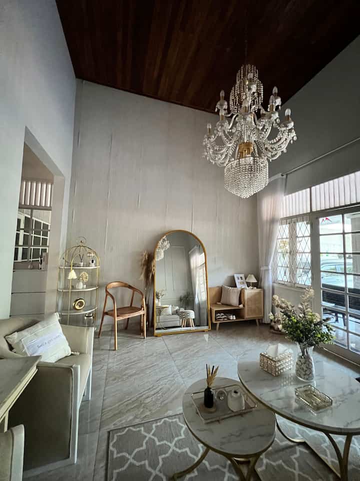 Modern cozy living room with white walls and wood-tone ceiling, featuring a sofa, coffee tables, and a large standing mirror