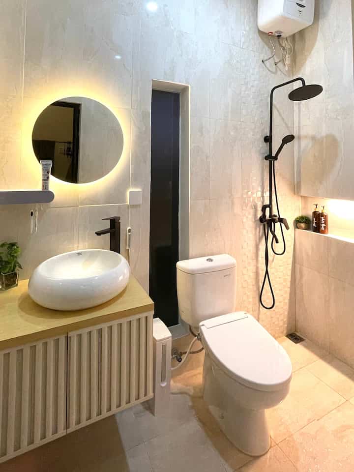Inilah tampak keseluruhan kamar mandi master bedroom yang berada dilantai 2. 
Kamar mandi ini mengusung tema minimalis menyesuaikan dengan luasnya yang minim. 
Keramik kamar mandi didominasi warna nude dipadukan dengan shower set hitam agar terlihat kontras.
Dan satu lagi menurut saya penting juga dalam pemilihan warna botol sabun & shampo disesuikan dengan dominasi warna nude dinding & lantai kamar mandi makanya saya pilih warna coklat dengan label putih sehingga kontras dengan dinding kamar mandi ini dan dengan ornamen hitam. 
Pada area wastafel saya lengkapi dengan kaca LED berbentuk bulat menyesuaikan bentuk wastafel. 

#aestheticroom
#aesthetichomedecor
#homestyling
#minimalist #roomdecorinspo #aesthetichomedecor #kamarmandiminimalis  #wastafelputih 
