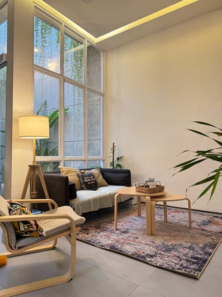 Ivory-toned walls and wood-tone furniture in a Japandi style living room, featuring warm lighting and a cozy atmosphere