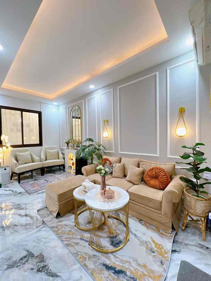 Beige and white toned living room featuring an L-shaped sofa and round coffee tables in a cozy modern space