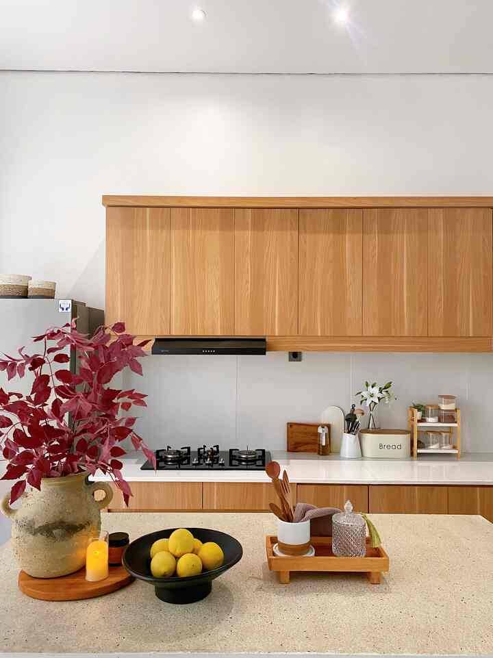 Dapur dengan nuansa kayu yang hangat , dengan vas bunga sebagai pemanis dan kitchen island untuk tempat berkumpul, serta peletakan meja makan di depan kitchen island untuk memudahkan menyajikan makanan #kitchenroominspiration #kitcheninspo #kitchenroomdecor #kitchenroominspiration #kitcheninspiration #kitchenideas