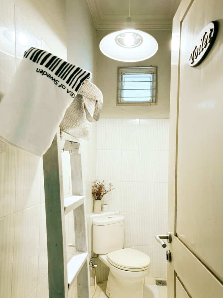 Dekorasi Toilet Mungil Untuk Tamu.

Toilet mungil ukuran 1x3m ini ,satu satunya toilet yang tidak berada di dalam kamar.Letaknya disamping ruang tamu,untuk tamu yang berkunjung atau sekedar berwudhu.
Toilet ini hanya ada wc dan kran,tidak dapat dipakai untuk mandi.

Agar terlihat lebih aesthetic,lampu yang semula bohlam biasa di plafon,aku ganti dengan lampu gantung putih Ikea.Cahaya lampu gantung cukup merubah suasana lebih nyaman.Tangga kayu cat putih sebagai gantungan handuk dan purun ukurannya tidak terlalu besar.Vas bunga kering dan lilin aromatherapy diletakan disudut dinding toilet.

Mau rapi rapi bercermin?Ada sebuah cermin besar di samping pintu toilet.

#bendafavorit
#recommendedfurniture
#recommendedDecorItems
#toiletmungil
