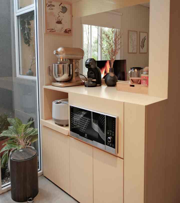 Beige and wood tone kitchen featuring coffee machine and cabinetry, creating a cozy home cafe corner