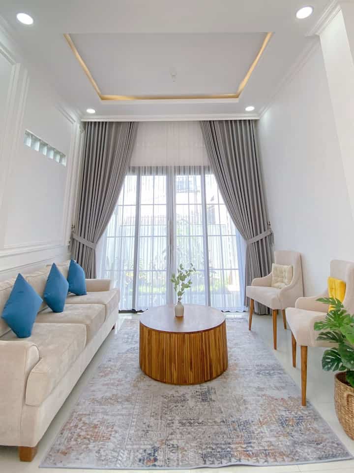 Ruang tamu dengan tema modern minimalis berukuran 3.3x6m. Berciri khas pintu kaca lebar dan gorden full plafond. Dilengkapi sofa besar, 2 kursi dan meja bulat jati berukuran 90cm. 

#liveSlowlyGoesToBandung #modernminimalis #homedecor #rumahminimalis #rumahmodern #modernhouse #bandung 