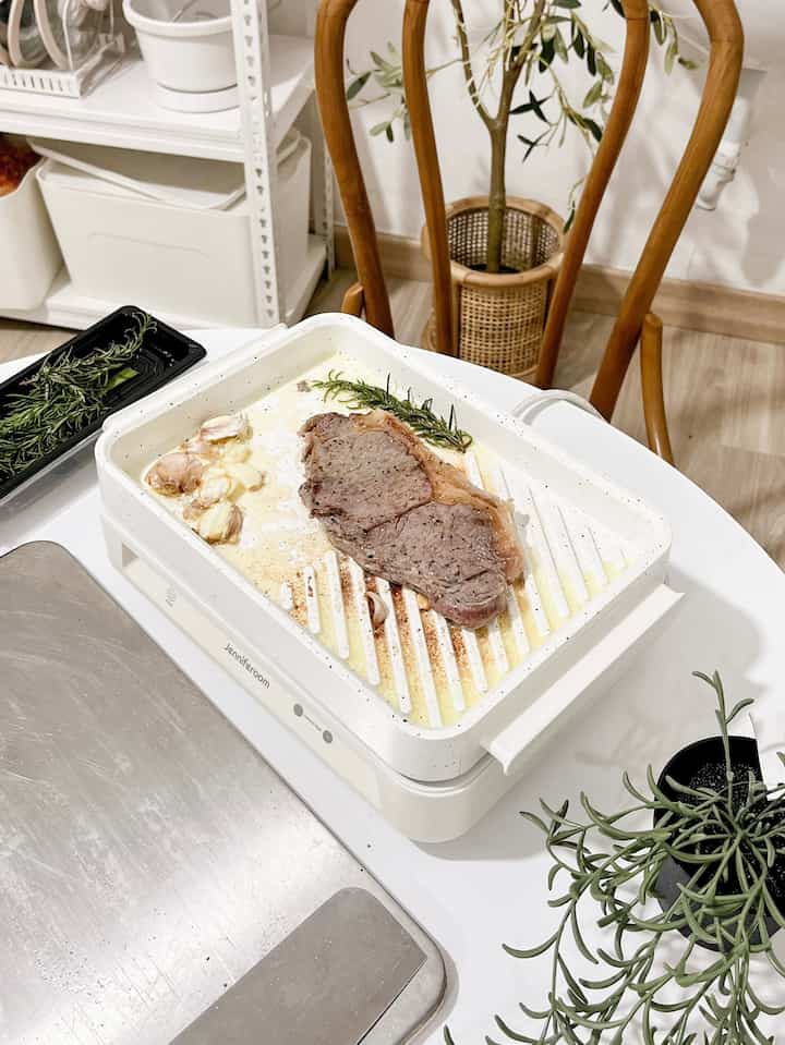 White and wood tone kitchen featuring cooking utensils and dining chair with a simple interior