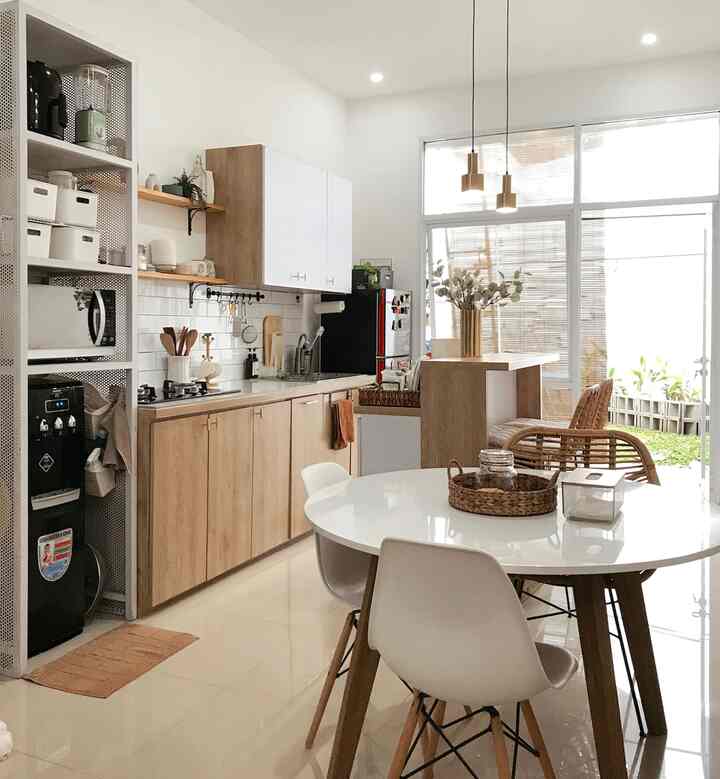 Bright white and wood tone kitchen and dining room with natural light, featuring cozy cafe-style ambiance