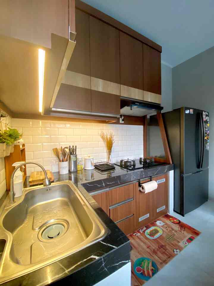 Dream Kitchen Story

Perjalanan panjang dapurku dari awalnya adalah dapur bawaan developer yang memang sudah ada kitchen set nya, hanya saja karena bawaan jadi lah kitchen set nya apa ada nya sehingga kami memutuskan untuk merombak sebagian.

Hal pertama yang kami fokuskan adalah mengganti sink bawaan developer yang ukurannya kecil ke sink yang ukurannya lebih besar dua kali lipat dari sink bawaan developer.

Hal selanjutnya kami fokuskan pada pemasangan kompor tanam, cooker hood, dan pembatas kulkas. Karena space dapur nya sangat terbatas maka space untuk kulkas pun terbatas dan kesalahannya yaitu penempatannya dekat dengan kompor.
Maka untuk meminimalisir paparan panas dari kompor ke kulkas maka kami pasangkan pembatas berbahan kaca tempered di dekat kompor dan kulkas.

Selanjutnya kami memodifikasi pintu kitchen set bagian bawah yang awalnya sama sekali tanpa ventilasi, kami beri lubang ventilasi untuk aliran panas kompor dan supaya tidak lembab juga.

Untuk perombakan dapur ini kami memang menyiapkan budget yang cukup besar khusus untuk pemilihan kompor dan sink, karena pertimbangan akan lama dipakai nya maka harus mencari yang benar benar berkualitas.

Setelah semua perombakan dirasa cukup, mulailah kami menata dapur sedikit demi sedikit, di awal kami masih memakai barang barang lama, tapi perlahan mulai diganti untuk menyelaraskan warna.

Sekarang sedikit demi sedikit dream kitchen mulai terbentuk meskipun masih belum sempurna seperti yang diinginkan, tapi pelan pelan mulai menuju ke arah itu

#MyDreamKitchen
#KitchenIdeas
#KitchenInspirations
#Minimalist
#RumahCluster
#RumahDeveloper
#Bandung


