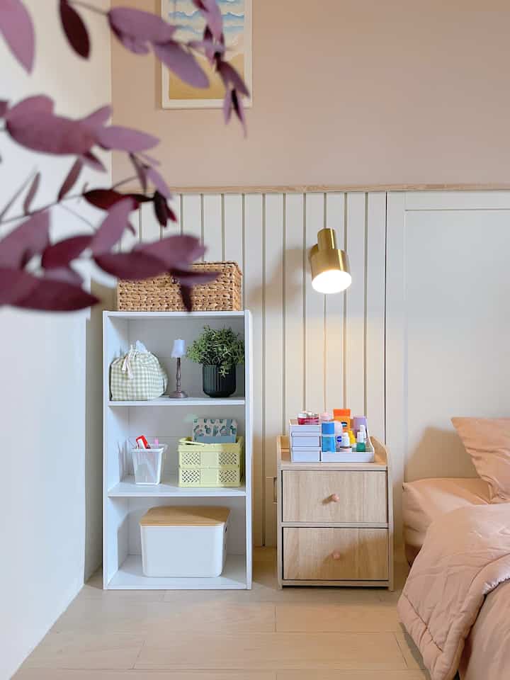 Natural-toned bedroom featuring a wooden nightstand and white shelving unit for storage, creating a cozy and neat interior
