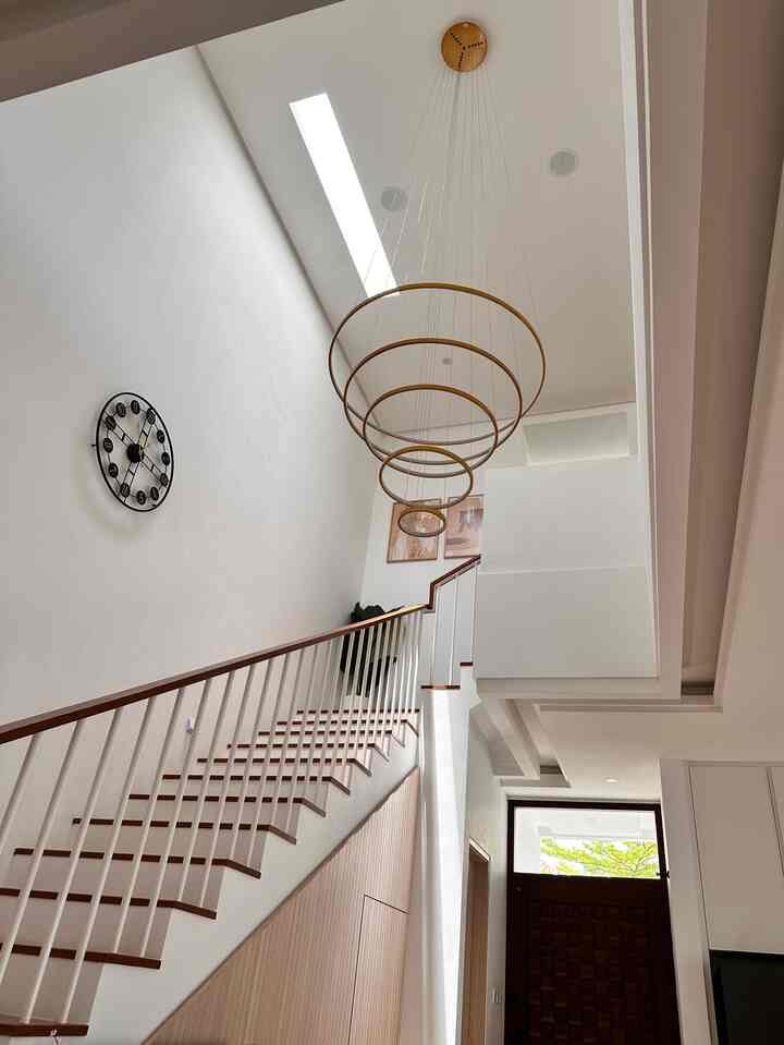 White and wood tone entrance stairway with high ceiling, featuring modern and minimal atmosphere