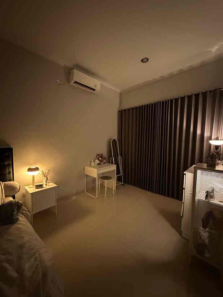 Warm beige-toned bedroom featuring a nightstand and vanity neatly arranged in a simple space