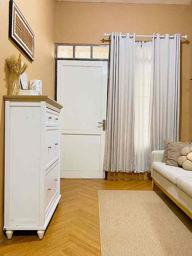 Natural white and brown toned living room featuring a white shoe cabinet, sofa, and curtains in a minimal cozy space