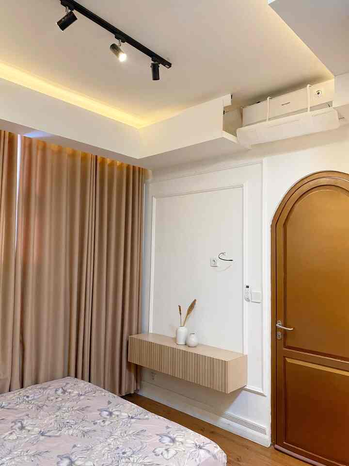 Brown and white toned bedroom featuring beige curtains and a floating storage cabinet with a neat atmosphere