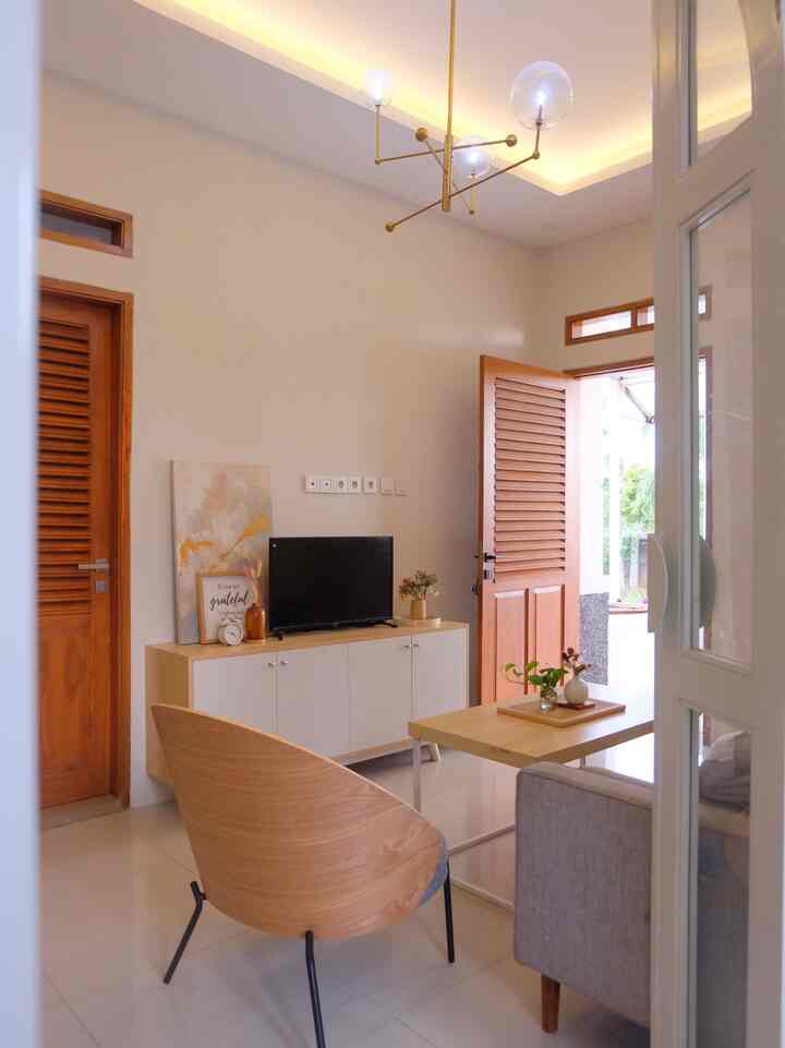 Hai! Senang sekali bisa kenal sama aplikasi ohouse ini, first time nih posting disini. Salam kenal yaaa tetangga online ku 😍

Perkenalkan, ini ruang tamuku, anggap kalian lagi main ke rumah ya 😍 Disini semua pintu jendela memakai kayu jati yang warnanya cenderung agak tua, supaya ga terlalu monoton, aku kombinasikan dengan meja tv dan coffee table dengan warna yang lebih muda. Meskipun berbeda warna, tapi karena masih sama motif kayu, jadi kelihatannya nyambung aja ya? 

Ditambah lounge chair dari informa yang sandarannya juga kayu, makin melengkapi ruang tamu ini. Di sisi kanan foto ini ada pintu lengkung mengarah ke taman, jadi ruang tamu ini punya pemandangan yang bagus. Kapan kapan aku spill yaa..

#dekorasiruangtamu #desainruangtamu

