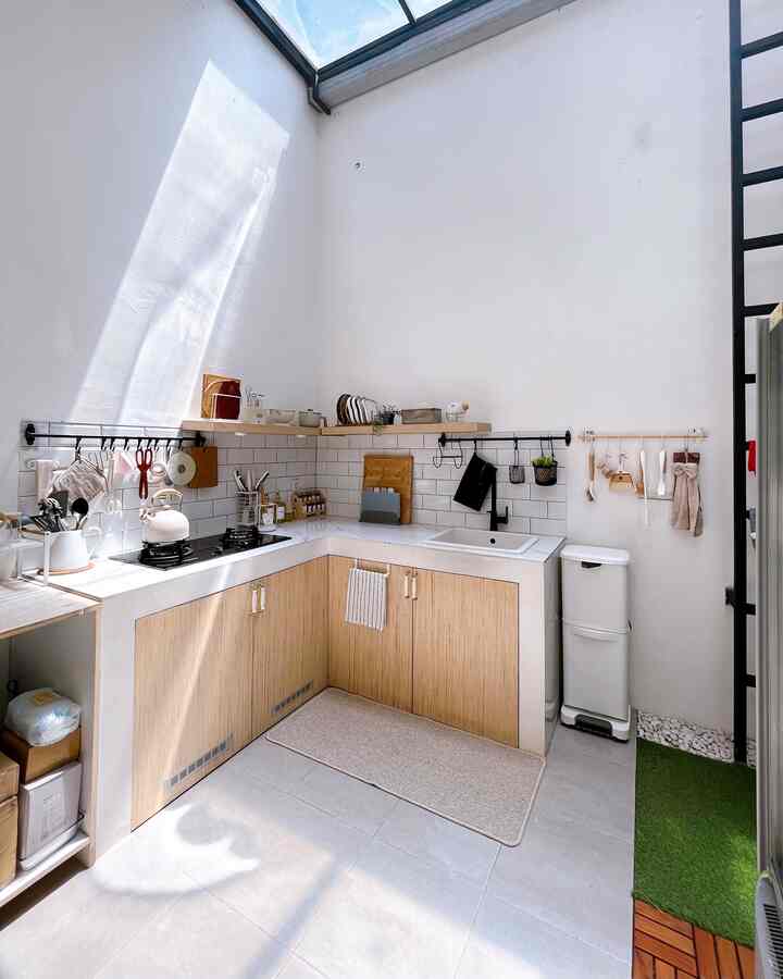 A kitchen space featuring wood tone and white colors, with a simple and minimalistic design.