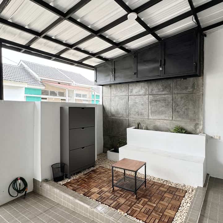 Gray and wood tone veranda space featuring a shoe cabinet, small table, and built-in bench creating a cozy atmosphere