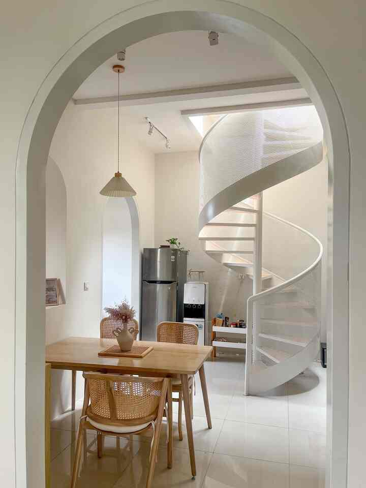 Talking about the theme of the house, this house is actually a combination of Japanese, minimalist white and wood themes. This house is dominated by teak wood doors and windows, to balance this, we chose wood-tone furniture for all the rooms.

Apart from the white and wood nuances, what is clearly a characteristic of this house is the curved frame and spiral staircase. The combination of curved & perforated iron and wooden patterned steps, makes this spiral staircase one of the beautiful spots in our house.

Because the interior of this house is already busy with the box shape of the doors, windows and also the curved shape of the frames and stairs, for the house paint we chose a neutral color and we matched it for the entire room, so that it wasn't too flashy and still had the same theme between one room and another. .

We also use a lot of rattan as a combination of wood in the furniture so that it is not monotonous. I also like adding real plants as home decoration to make it look fresher and cooler.

#japandi #homedecorinspo #rumahestetik #pintulengkung #whiteandwood