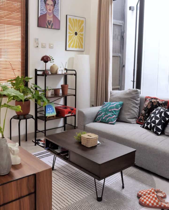 Style penataan interior di seluruh ruangan Daśa Cavana adalah Tropical Industrial. Aku menggunakan tanaman sebagai media “segar” dalam ruangan yang tidak terlalu luas ini. Warna coklat yang aku pilih cenderung ke arah coklat Walnut, karena aku suka warna coklat tua yang terlihat lebih klasik dan longlasting. 

I loveee colors! Aku pakai kombinasi warna kayu dan tambahan warna RGB sebagai item dekoratif yang membuat ruangan lebih terasa hangat sekaligus ceria. Karena aku punya hobi digital painting, aku membuat beberapa dekorasi pigura dan juga carpet/rug secara custom. 

Agar rumah terasa lapang, aku mendesain open space untuk ruang keluarga, ruang makan dan dapur. Aku juga meminimalisir barang-barang kecil dan memaksimalkan rak tertutup sebagai area simpan untuk membuat ruangan lebih terorganisir. :)

#tropicalindustrial #tropical #industrial #rustic #livingroom #ruangkeluarga #openspace #homedecorinspo #roomdecorinspo #rumahestetik 
