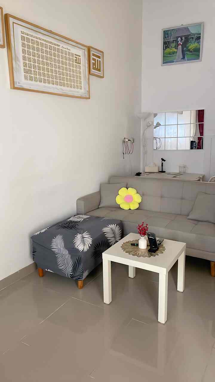 White and gray toned small living room featuring a Scandinavian-style sofa and simple table creating a clean space
