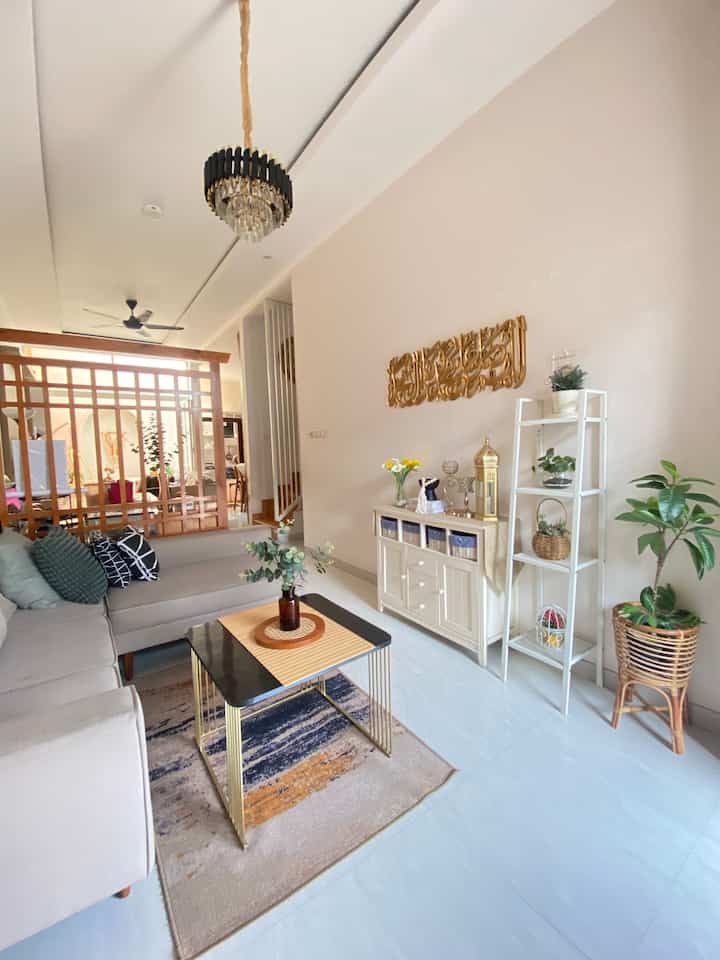 A white and brown wood-tone living room featuring simple natural furniture and plants creating a cozy atmosphere