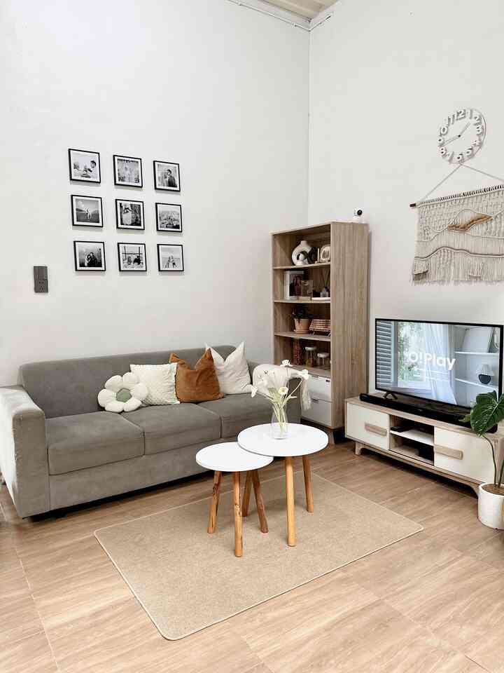 Natural toned living room with white walls, wood floor, gray sofa, and white round coffee tables creating a cozy modern atmosphere