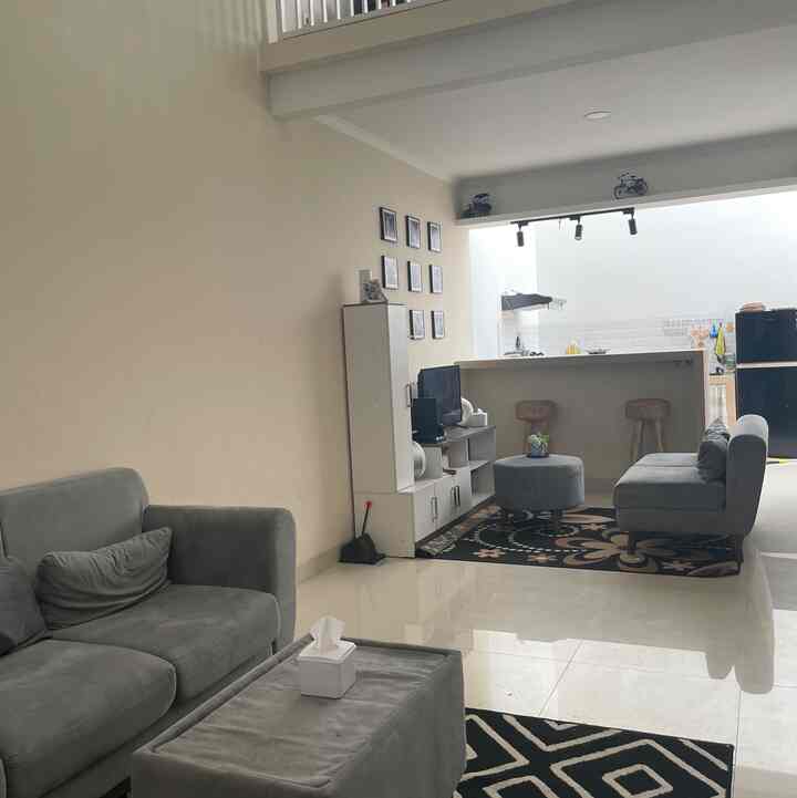Natural toned open space living room and kitchen featuring gray sofas and beige walls with a simple, airy atmosphere