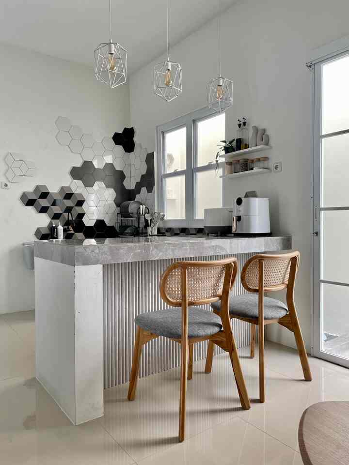 White and gray toned industrial minimal kitchen featuring wood dining chairs and concrete kitchen island