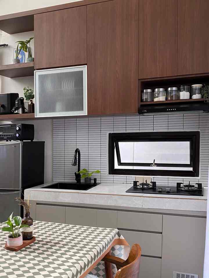 Gray and brown toned kitchen featuring a compact space with modern cabinetry and a gas stove, showcasing practical design