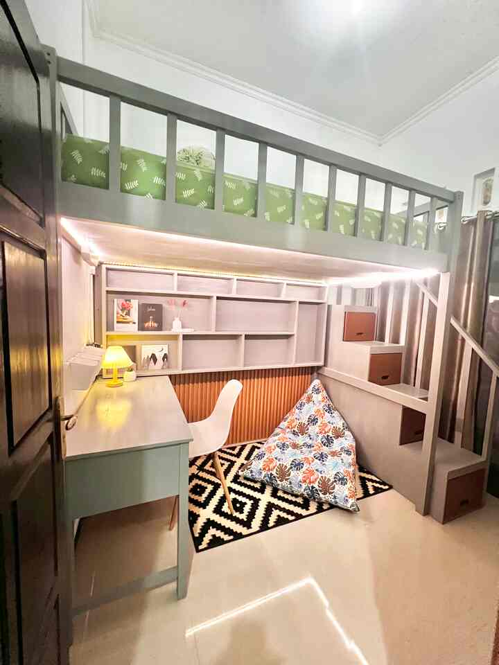 White and green toned small single household loft room, featuring a desk and bean bag in a modern, tidy setting