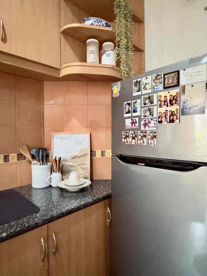 Beige-toned kitchen space featuring a stainless steel refrigerator and tableware, creating a warm atmosphere