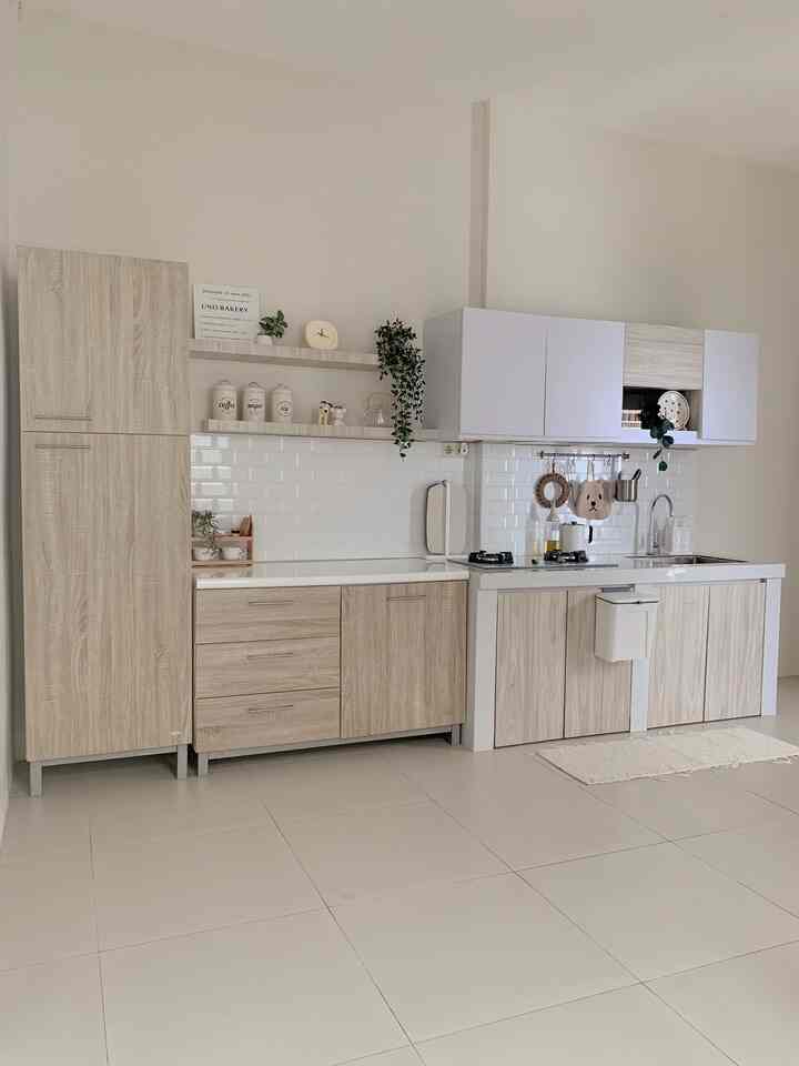 A clean and organized kitchen space blending natural tones with white elements, featuring wood-toned cabinets and white tiled walls