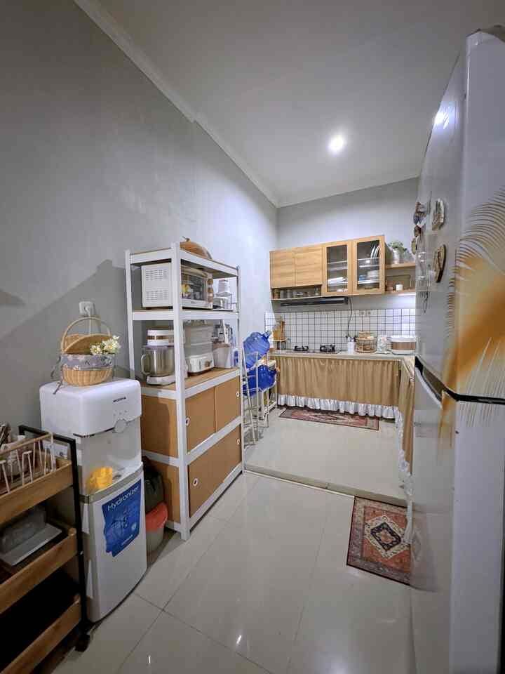 White and brown toned compact kitchen featuring multiple storage cabinets with a neat atmosphere