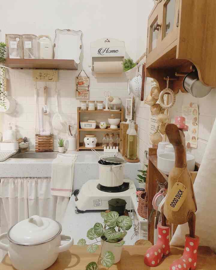 Natural and cozy kitchen space in white and wood tones featuring organized storage ideas and various kitchen utensils